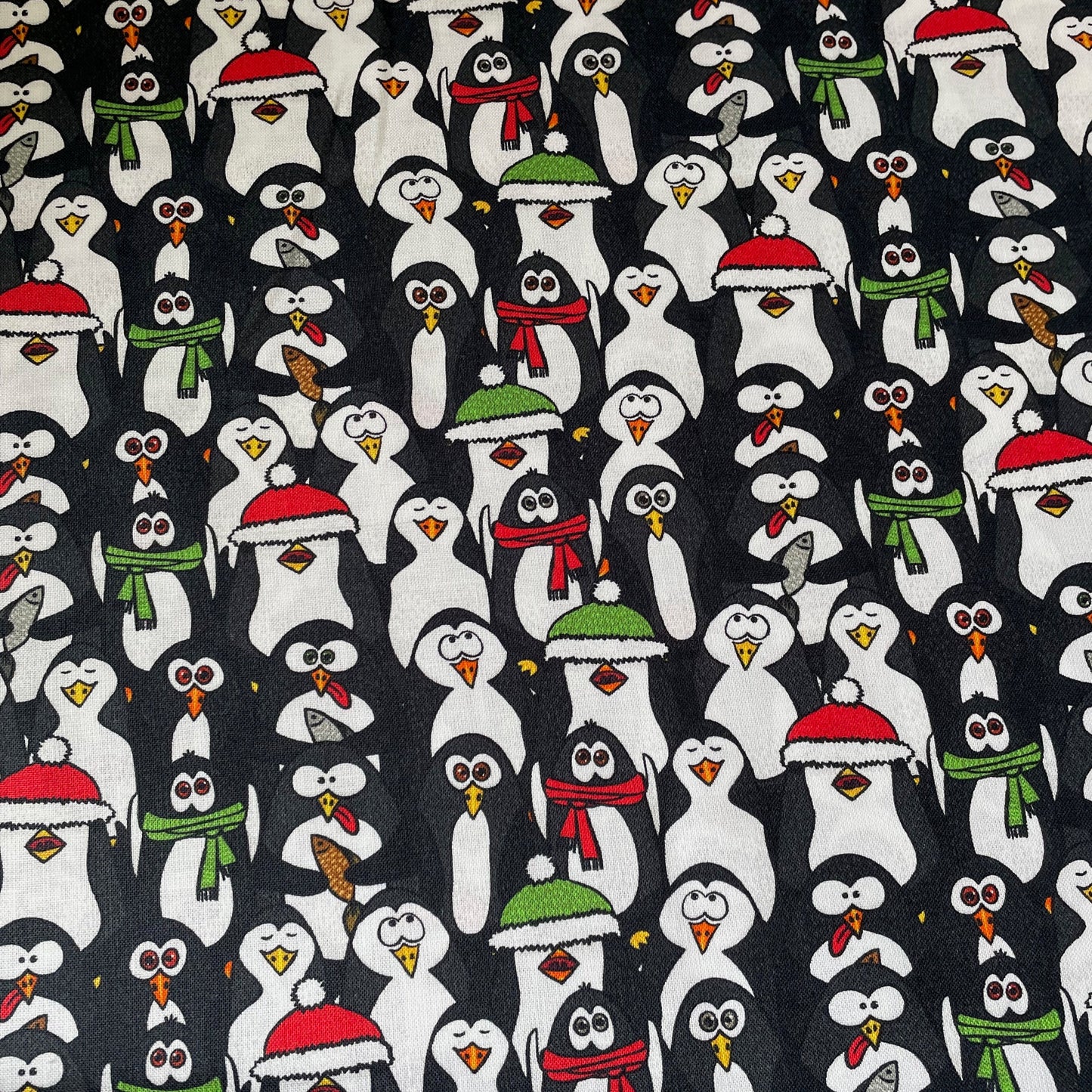 Pattern of cartoon penguins wearing winter hats and scarves on a black background