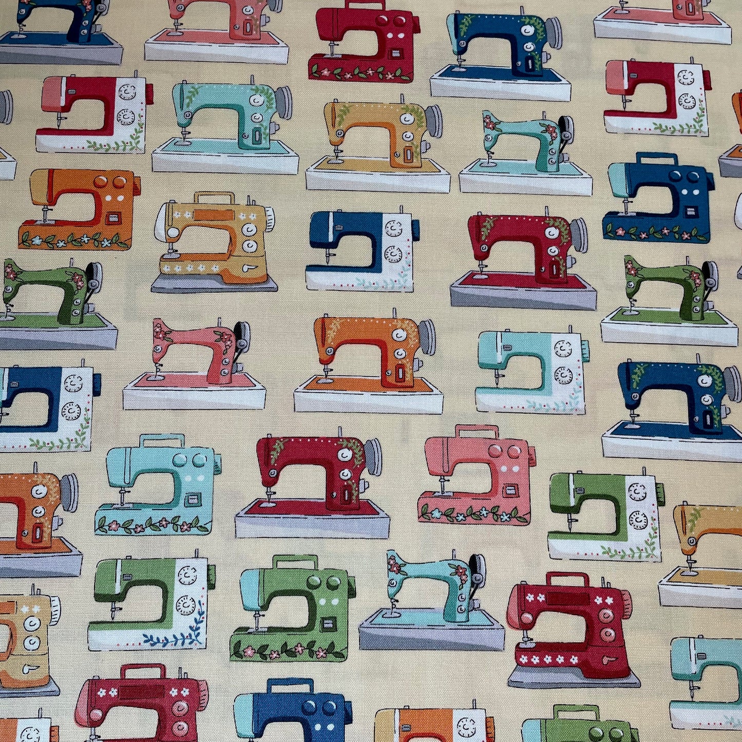 Pattern of colourful sewing machines on a light yellow background