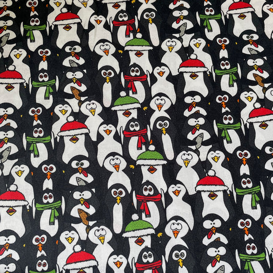 Pattern of cartoon penguins wearing winter hats and scarves on a black background